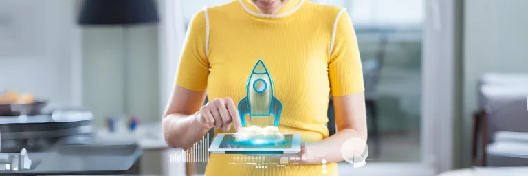 Frau hält iPad, aus dem eine Rakete kommt. Soll als Symbol für den Start einer eigenen Praxis dienen.