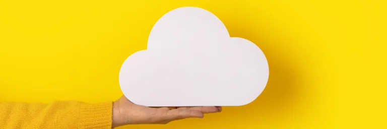 Eine Hand hält eine Wolke vor einem geben Hintergrund.