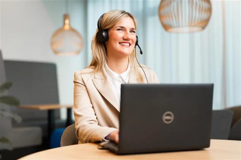 Frau mit Headset am Laptop